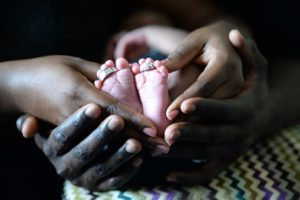 Parents holding a newborn babies toes