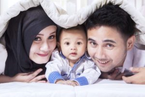 A muslim family peeks under a blanket